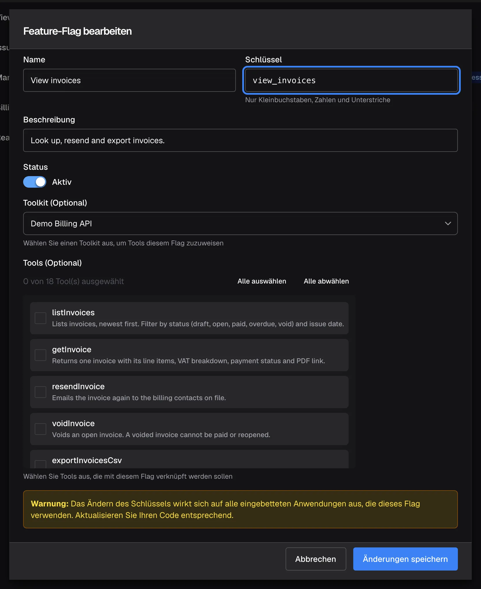 Der Dialog „Feature-Flag bearbeiten“ für die Richtlinie „View invoices“. Das hervorgehobene Feld „Schlüssel“ zeigt view_invoices, den Namen, unter dem die Richtlinie geführt wird. Darunter folgen „Beschreibung“, der Schalter „Status“ auf Aktiv, „Toolkit (Optional)“ mit Demo Billing API und „Tools (Optional)“; der Zähler zeigt „0 von 18 Tool(s) ausgewählt“ und kein Kästchen ist angehakt, obwohl die Liste vier Tools für diese Richtlinie zeigt. Ein Kasten „Warnung:“ weist darauf hin, dass eine Änderung des Schlüssels alle einbettenden Anwendungen betrifft; unten stehen „Abbrechen“ und „Änderungen speichern“.