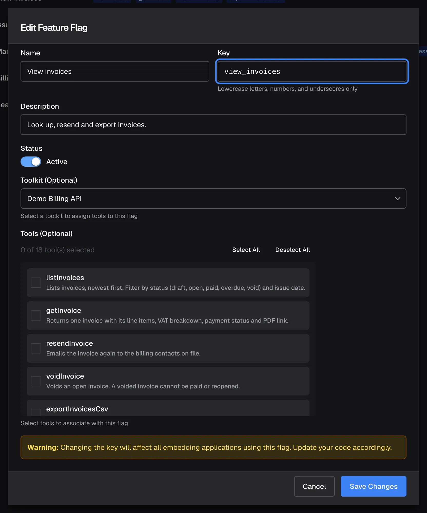 The "Edit Feature Flag" dialog for the policy "View invoices". The highlighted "Key" field shows view_invoices, the name the policy is known by. Below are "Description", the "Status" switch set to Active, "Toolkit (Optional)" with Demo Billing API and "Tools (Optional)", where the counter reads "0 of 18 tool(s) selected" and no box is ticked, although the list page shows four tools for this policy. A "Warning:" box says that changing the key affects every embedding application using it; "Cancel" and "Save Changes" sit at the bottom.