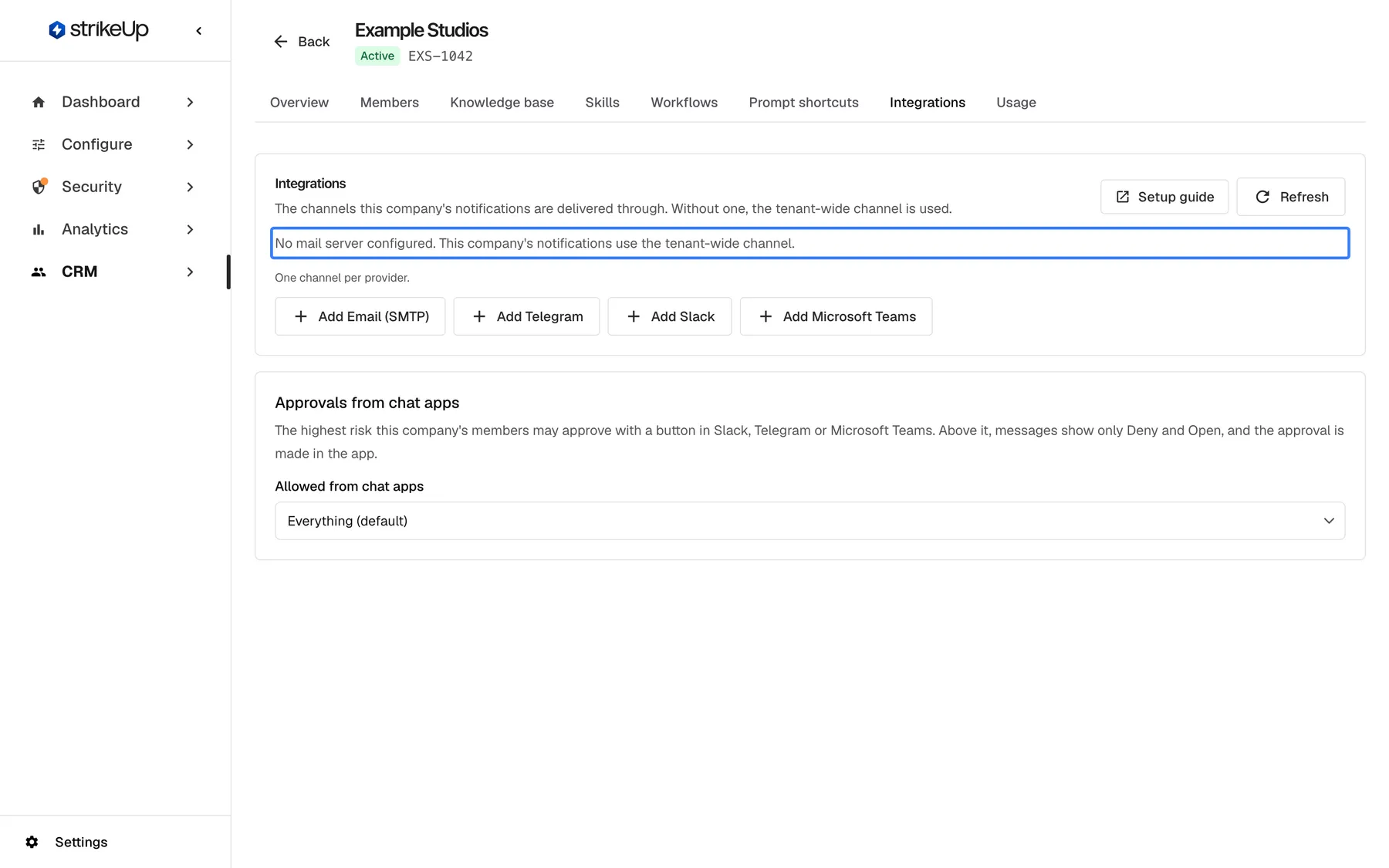 The Integrations tab of "Example Studios" with no channel of its own. The highlighted text reads "No mail server configured. This company's notifications use the tenant-wide channel." Below it, "One channel per provider." and the buttons "Add Email (SMTP)", "Add Telegram", "Add Slack" and "Add Microsoft Teams"; under them the card "Approvals from chat apps". "Setup guide" and the refresh button are at the top right.