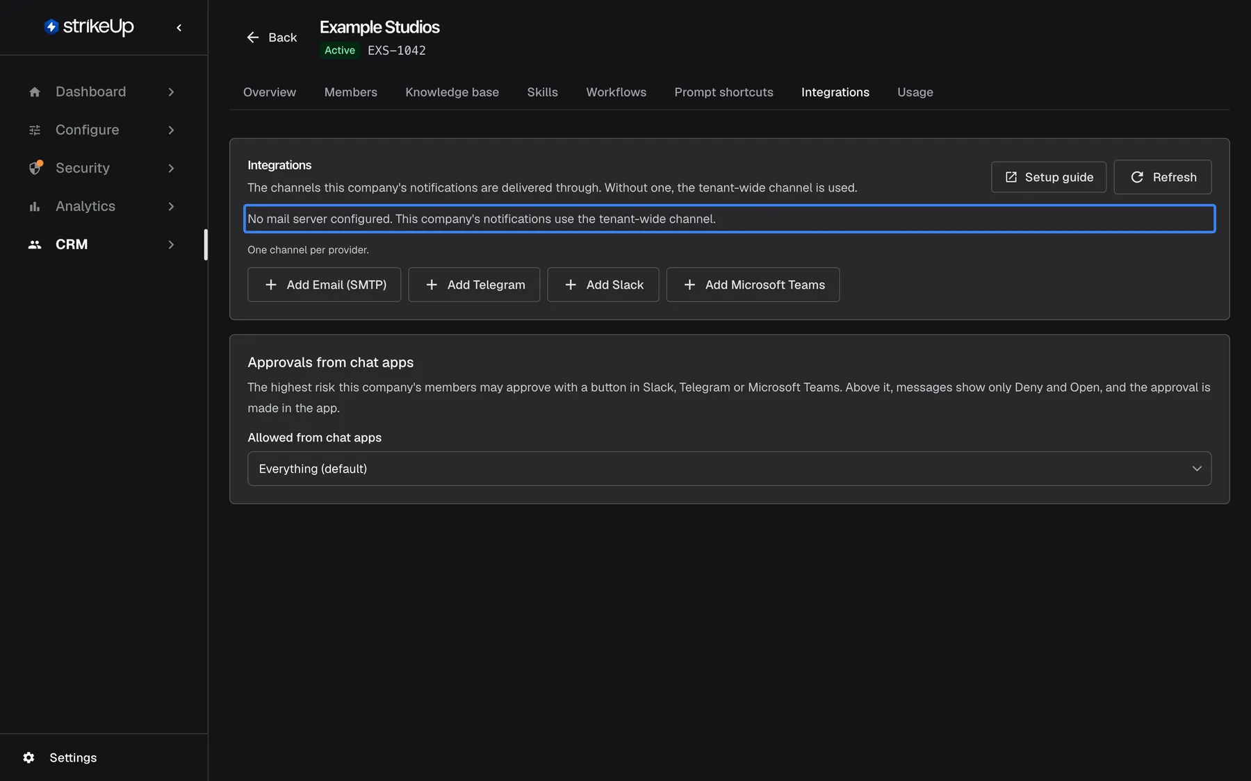 The Integrations tab of "Example Studios" with no channel of its own. The highlighted text reads "No mail server configured. This company's notifications use the tenant-wide channel." Below it, "One channel per provider." and the buttons "Add Email (SMTP)", "Add Telegram", "Add Slack" and "Add Microsoft Teams"; under them the card "Approvals from chat apps". "Setup guide" and the refresh button are at the top right.